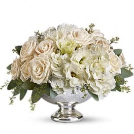 White and blush roses with white hydrangeas in a silver pedestal bowl