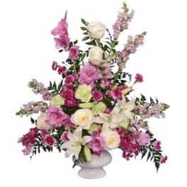 Pink and white floral arrangement in a white pedestal vase
