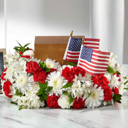 Red and white floral arrangement with two small American flags