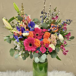 Colorful mixed bouquet in a tall glass vase