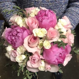 Bouquet of pink peonies, roses, and white mini roses with greenery