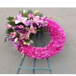 Pink floral wreath with lilies and roses on a stand