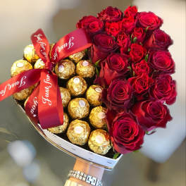 Heart-shaped bouquet of red roses and gold-wrapped chocolates with red ribbons
