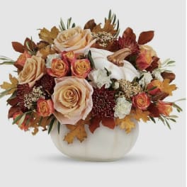 Autumn floral arrangement with roses and a white pumpkin in a white vase