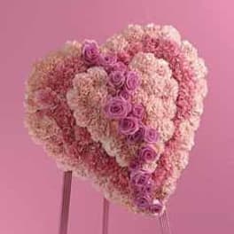 Heart-shaped pink floral standing arrangement with roses and carnations