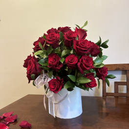 Bouquet of red roses in a white hatbox with a ribbon
