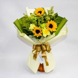 Bouquet of sunflowers and yellow flowers wrapped in cream and green paper