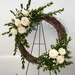 Circular floral wreath with white roses and small white daisies on a twig base