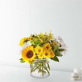 Yellow and white mixed bouquet in a clear glass vase