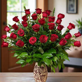 Red roses arranged in a patterned vase