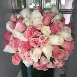Bouquet of pink and white roses in a dark glass vase