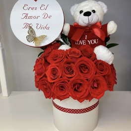 Red rose arrangement with a teddy bear and heart-shaped sign in a white box