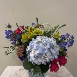 Mixed bouquet with blue hydrangea in a glass vase