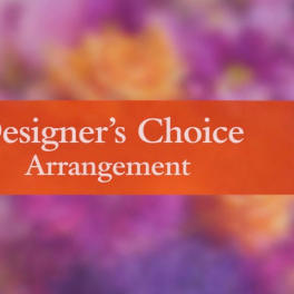 Designer’s Choice Arrangement sign over a blurred floral background
