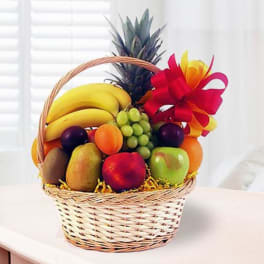 Fruit basket with bananas, grapes, apples, and a pineapple