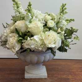 White roses and hydrangeas arranged in a stone urn
