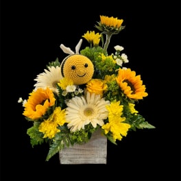 Sunflower and daisy arrangement with a crocheted bee in a wooden box