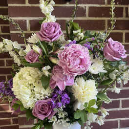 Pink roses and peonies in a white vase with white and purple flowers