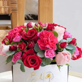 Bouquet of red and pink roses with carnations in a white box
