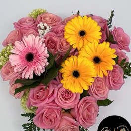 Pink roses with yellow and pink gerbera daisies in a bouquet
