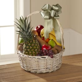 Wicker basket filled with assorted fruit and topped with a ribbon bow