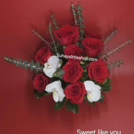 Red roses and white orchids arranged on a red background