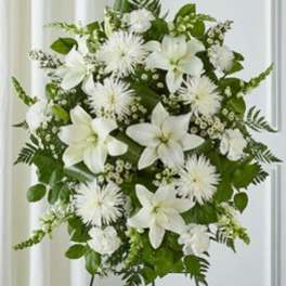White lilies and daisy-like flowers in a standing arrangement