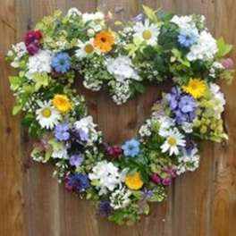 Heart-shaped floral wreath with mixed daisies and colorful blooms