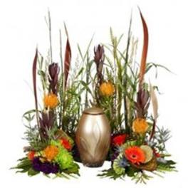 Tropical floral arrangement with orange blooms and a gold urn centerpiece