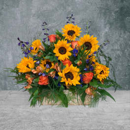 Sunflowers and orange roses arranged in a low rectangular container