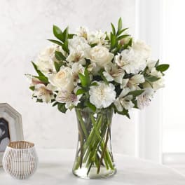 White roses and carnations in a clear glass vase
