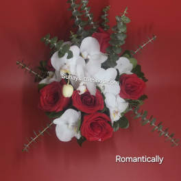 Red roses and white orchids with eucalyptus on a red background