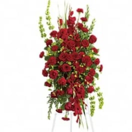 Tall standing spray of red roses on a white easel