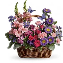 Basket of pink and purple flowers with butterfly decorations