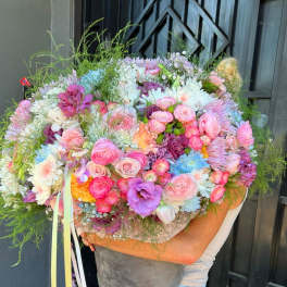 Large pastel bouquet in a gray bucket with pink, white, and purple flowers