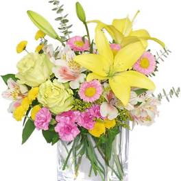 Mixed bouquet of yellow lilies, pink daisies, and white flowers in a glass vase