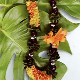 Two floral leis with orange and yellow flowers on large green leaves.