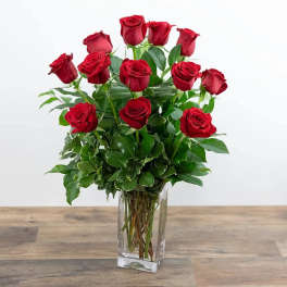 Red roses arranged in a clear glass vase