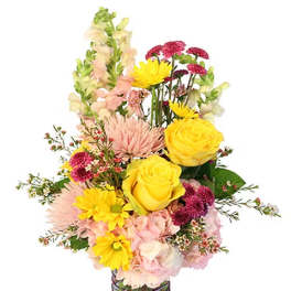 Mixed bouquet of yellow roses, pink blooms, and snapdragons in a glass vase