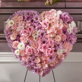 Heart-shaped pink and lavender floral arrangement on an easel