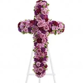 Purple and pink floral cross on a white stand