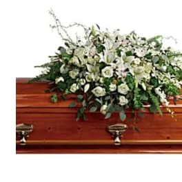 White floral spray on a wooden casket