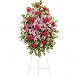 Standing floral spray of pink and red flowers on a white easel