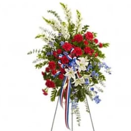 Standing floral spray with red, white, and blue flowers on an easel