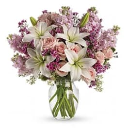 Bouquet of pink roses and white lilies in a clear glass vase