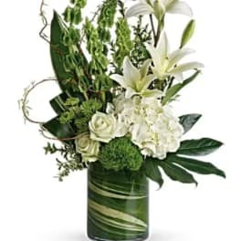 White lilies and roses in a green glass vase