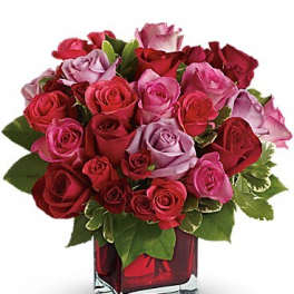 Bouquet of red and pink roses in a square glass vase