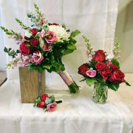 Bouquet of red and pink roses with white blooms, plus a matching boutonniere