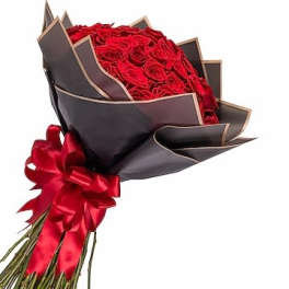 Bouquet of red roses wrapped in dark paper with a red ribbon