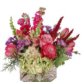 Pink and purple mixed bouquet in a square glass vase